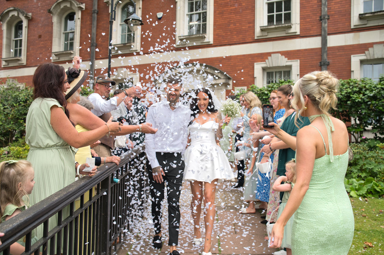 A new grooming bride walked down from the Stockport registry office while their guests throw confetti all over them