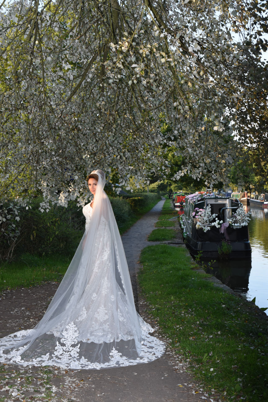 The bride poses at sunset next to the Macclesfield Canal at her wedding at lyme breeze wedding venue Macclesfield